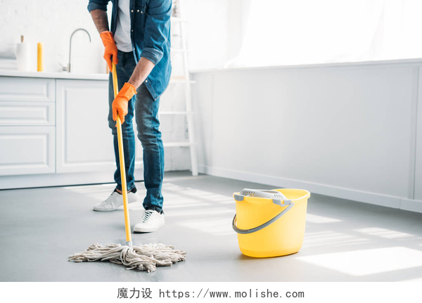 在卧室里打扫家务的男人厨房用拖把清洗地板的裁剪图像
